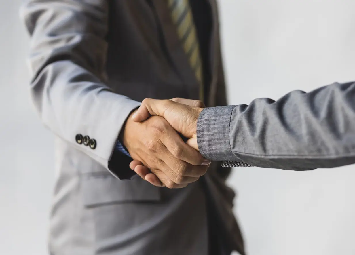 Handshake, business people reach out to shake hands.